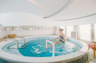 A modern, sleek cold plunge tub in a spa setting, with crystal clear water, surrounded by minimalist decor, a person stepping into the tub, natural lighting and a calm atmosphere