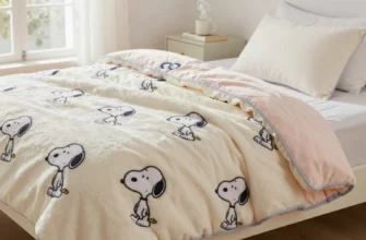 A cozy bedroom scene featuring a plush, pastel-colored weighted blanket with a classic Snoopy cartoon pattern draped over a neatly made bed. The blanket looks thick and comforting, with subtle stitching details. Soft natural light streams through a window, highlighting the blanket's texture. A small, stylish nightstand with a steaming mug and a book sits nearby, emphasizing relaxation. No text, logos, or watermarks are present.