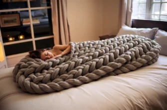 A cozy bedroom scene at night, featuring a person peacefully sleeping on a large, intricately braided weighted blanket draped over a comfortable bed. The blanket should have a textured, woven appearance with subtle color variations, and the room should have soft ambient lighting, a nightstand, and a window with curtains. The overall mood is calm and restful, emphasizing the comfort and weight of the blanket.