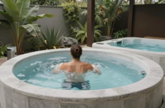 A serene outdoor setting featuring a modern cold plunge spa surrounded by lush greenery and natural elements. The spa is filled with clear, icy water, and a person is depicted in the process of entering or exiting the spa, showcasing the contrast therapy experience. The scene includes a nearby hot tub or sauna to highlight the contrast therapy aspect. The overall atmosphere is tranquil and inviting, emphasizing the benefits of cold plunge spas and contrast therapy.