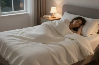 A cozy bedroom scene showing a person peacefully sleeping under a weighted blanket quilt, with soft ambient lighting, a nightstand with a small lamp and a book, and a window showing a dark starry sky outside. The blanket has a subtle textured weave and gentle folds, emphasizing comfort and calm. The atmosphere is serene and restorative, symbolizing the evolution of sleep technology toward deeper relaxation.