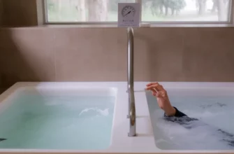 A modern dual hot and cold plunge pool setup, side by side, with clear water, a thermometer indicating temperatures, a person stepping into the cold side, surrounded by a spa-like environment, no text or signage