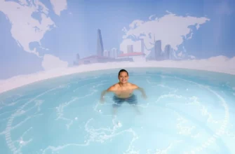 A person standing in a clear, icy cold plunge pool surrounded by a subtle globe or world map backdrop, with a hint of Melbourne's skyline in the distance, capturing the global nature of cold plunging