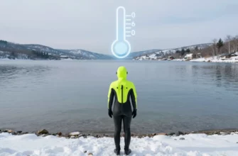 A person in a bright wetsuit standing on a snowy shoreline, looking at a clear icy lake with a subtle frost overlay, a faint thermometer icon integrated into the scene showing a safe temperature range, surrounding winter landscape with gentle waves and distant snow-capped hills, emphasizing the concept of a safe polar plunge without any text or symbols