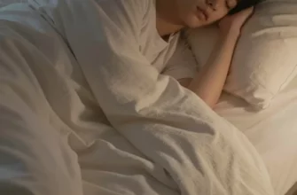 A person sleeping peacefully in a comfortable bed with a king-size, light-weight blanket. The blanket is softly draped and appears to be made of a breathable material. The room is dimly lit and cozy. Focus on the blanket's texture and how it contributes to a restful sleep.