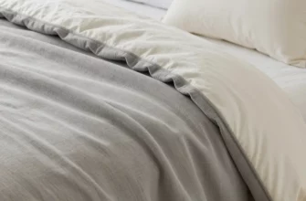 A cozy bedroom scene with a variety of weighted blankets draped over a bed, showcasing different textures and colors. Include a nightstand with a lamp and books. Focus on the blankets' tactile appearance and how they fit on the bed.