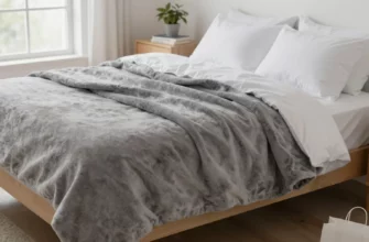 A cozy bedroom scene featuring a neatly made bed with a plush, gray weighted blanket draped over it, soft natural lighting from a nearby window, a small nightstand with a plant and a book, and a subtle hint of a Walmart shopping bag partially visible on the floor, without any visible logos or text.