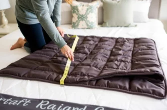 A person measuring a weighted blanket on a bed, holding a measuring tape, with the blanket neatly spread out. The scene should include a cozy bedroom setting with soft lighting, a comfortable mattress, and a few decorative pillows. The person should be focused on the task, ensuring the blanket is measured accurately for the perfect fit.
