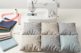 A detailed, flat lay photograph showcasing the process of making a weighted blanket. Include a sewing machine, fabric scraps (various colors and textures), a measuring tape, thread, safety pins, and a partially completed weighted blanket. The blanket should be in a neutral color palette (e.g., gray, beige, light blue). Focus on the tools and materials used in the sewing process.