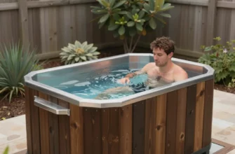 A professional cold plunge pool installation in a backyard in Allen, TX. The pool is made of dark wood and has a stainless steel finish. There are plants and greenery surrounding the pool, and a person is preparing to use the cold plunge. The scene is well-lit and shows the pool in its finished state.