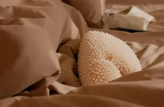 A cozy bedroom scene. A duvet cover is partially open, revealing a weighted blanket inside. The blanket is soft and plush, contrasting with the smooth fabric of the duvet cover. Soft, warm lighting. Focus on the textures of the blanket and duvet cover.
