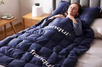 A cozy bedroom scene featuring a person relaxing under a 12lbs weighted blanket with the brand name 'Tranqui' subtly visible on the blanket, soft lighting, and a calm atmosphere