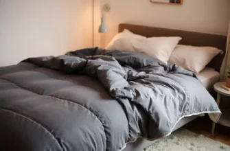 A cozy bedroom scene featuring a neatly made bed with a large, soft, deep gray weighted blanket draped evenly over it, subtle texture visible on the blanket, warm ambient lighting, minimalist decor, no text or numbers visible