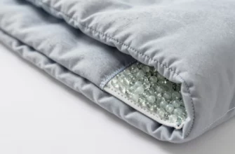 A detailed close-up view of a weighted blanket's construction showing the fabric layers, internal weighted pockets filled with glass beads or plastic pellets, and the outer fabric loops sewn onto the blanket's surface, with clear visibility of the stitching and material texture, educational and informative style
