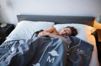 A serene bedroom scene with a person peacefully sleeping under a weighted blanket, soft ambient lighting, subtle medical symbols like a calm moon or gentle wave patterns integrated into the blanket design, no text or numbers visible