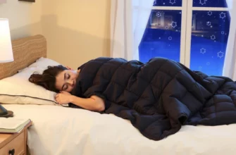 A cozy bedroom scene showing a person peacefully sleeping under a weighted blanket, with soft ambient lighting, a nightstand with a lamp and a book, and a window showing a dark starry sky outside. The blanket is slightly pulled up to the chest, emphasizing its gentle pressure and comfort. The atmosphere is calm, warm, and inviting, highlighting the soothing effect of the blanket.